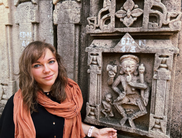 Sandra standing next to a Chamunda sculpture of a temple in Thubon